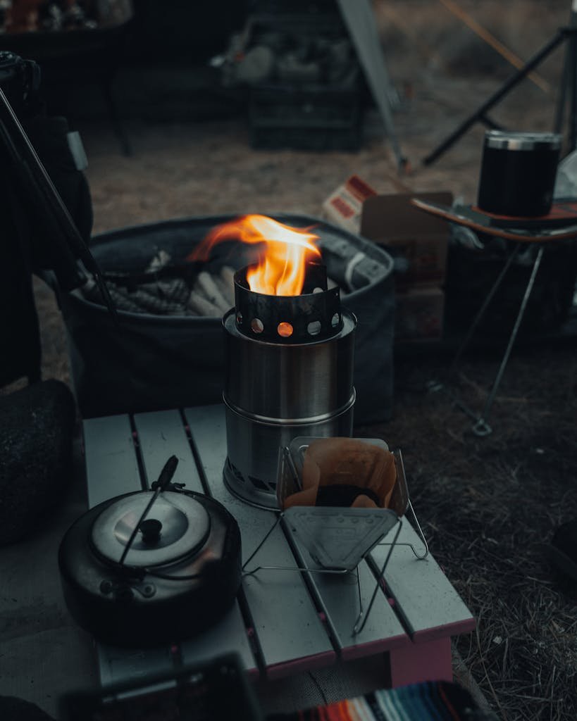 Close-up of a camping stove with flames, set outdoors in a cozy Japanese campsite.