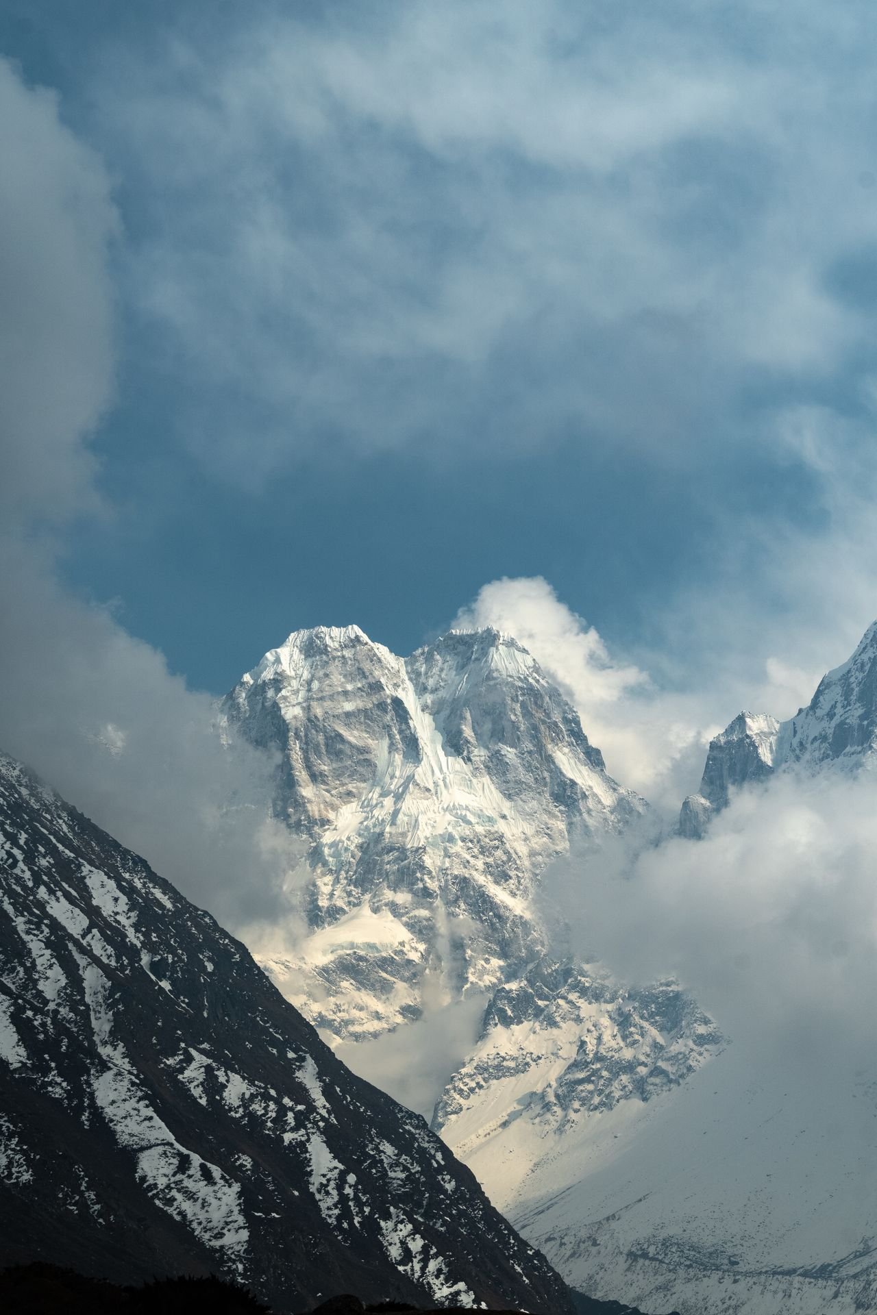 Breathtaking view of snow-covered mountains in Phungling, Nepal, under a dramatic cloudy sky.