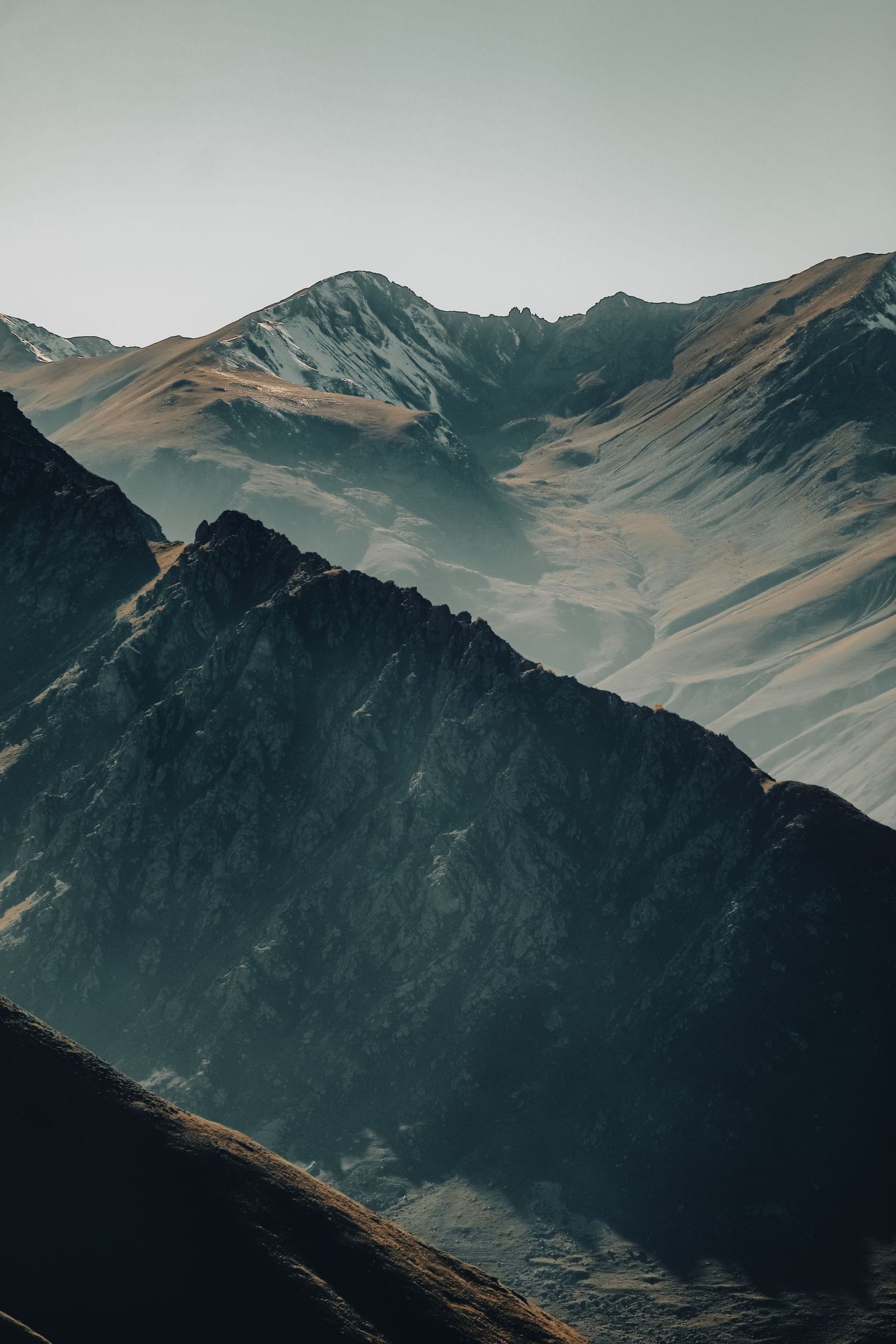 Captivating view of a rugged mountain range basking in early morning light, creating dramatic shadows.